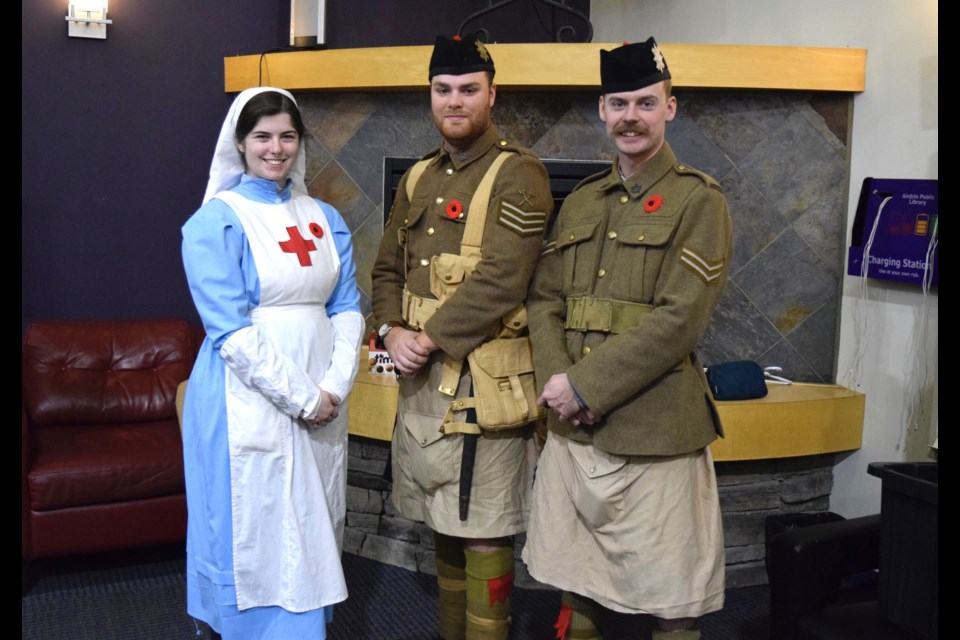 (L-R) Taylor O'Sullivan, Marcus Nielsen, and Galen March portray a Canada's Nursing Sister and soldiers of the Royal Highland Regiment at the Airdrie Public Library on November 2. 