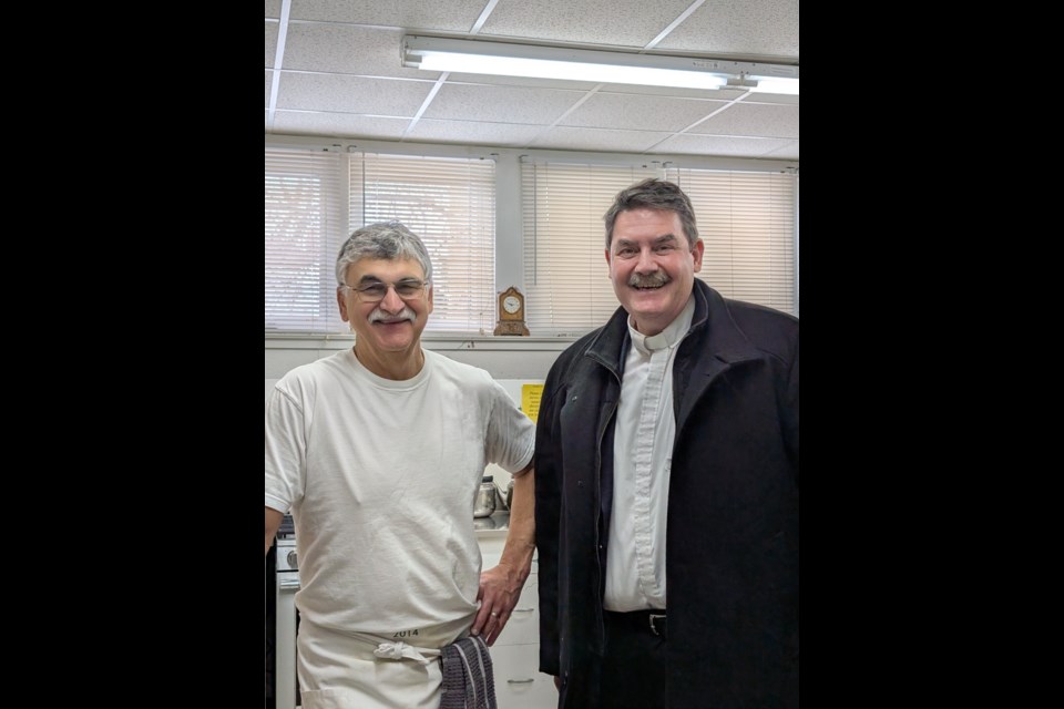 Rev. Andrew Comar is on hand at the Aurora Community Café with volunteer chef Tony Maio.