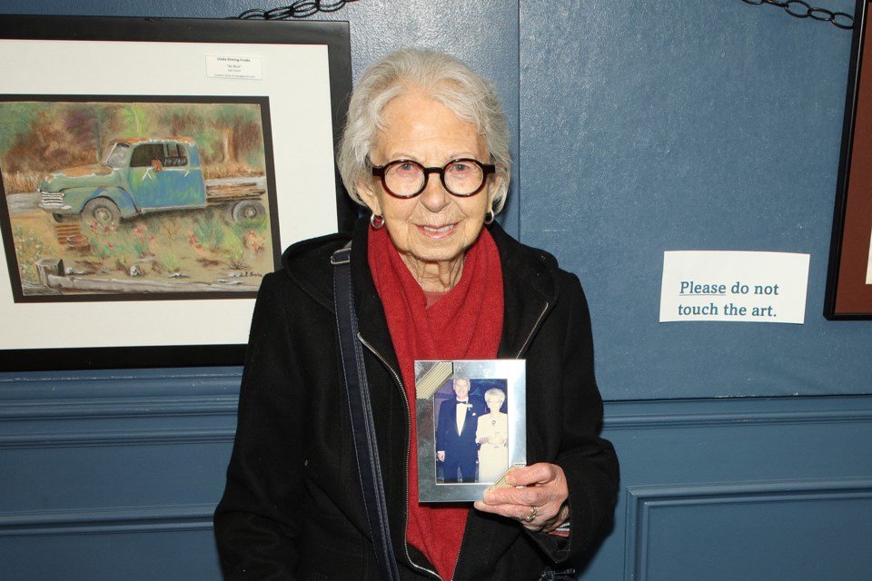 Hugette Ivany holds a photo of her and her husband. It was her husband's poetry that inspired Alexis Gada to organize CHATS' first community arts showcase at the Aurora Legion Jan. 18. 