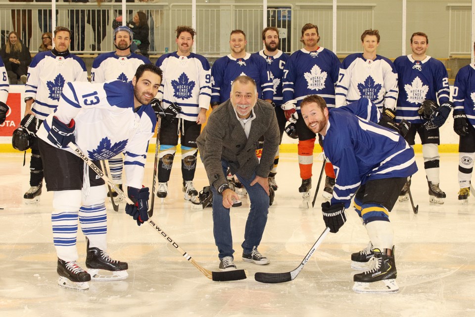 Aurora Mayor Tom Mrakas drops the ceremonial puck for the second annual Hockey Ends Hunger charity game Nov. 30 at the Sports Aurora Recreation Complex.