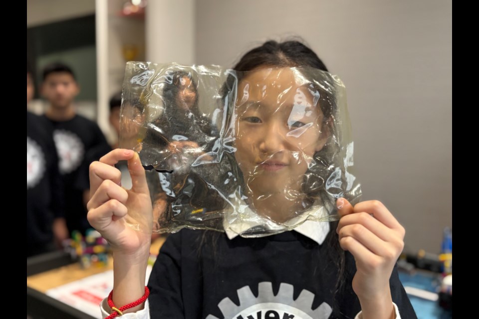 Renee Zhang holds up her team's innovation project, a biodegradable sheet of plastic, made out of seaweed.