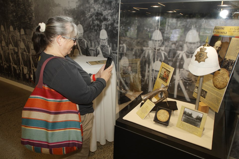 Jocelyn Kean, who lives across the street, photographs a display of artifacts at the 150th anniversary event at the Aurora Armoury Saturday.  She loves how the old building was given a new life and how Niagara College, the new operators, shares with the community.