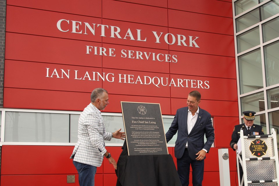 Aurora Mayor Tom Mrakas and Newmarket Mayor John Taylor unveil the plaque dedicating Fire Station 4-5 to late fire chief Ian Laing Saturday morning.