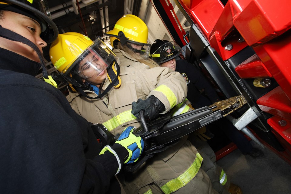 Sierra Henderson helps Terina Rajanayagan work the jaws of life at Central York Fire Services' fourth annual INSPIRE event in celebration of International Women’s Day at its Aurora Station 4-5 Saturday.  