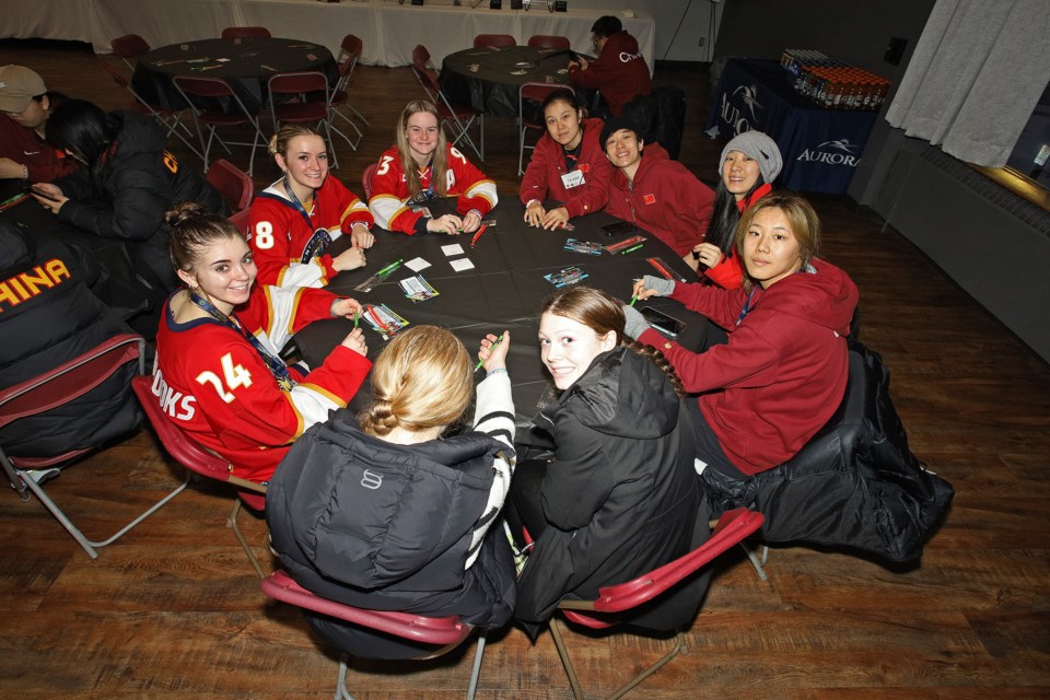 Members of the U22 Central York Girls Hockey Association Panthers and Team China gather following a hard-fought game won by Aurora in overtime, 2-1, Sunday afternoon.