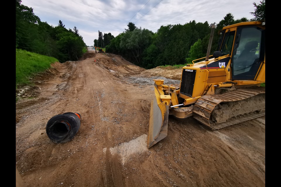 An earth mover blocks Essa Township's Line 5 where a slope failure has closed the road since April.