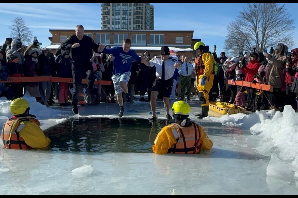 Barrie police Insp. Carl Moore, local Special Olympian Nick Cunningham and Chief Rich Johnston splash into the icy water of Kempenfelt Bay during the Polar Plunge on Saturday.