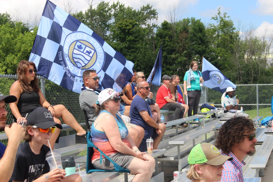 Fans of the The Simcoe County Rovers FC Men’s Team cheer from the stands as the team takes on the Hamilton United Men on July 6, 2024.