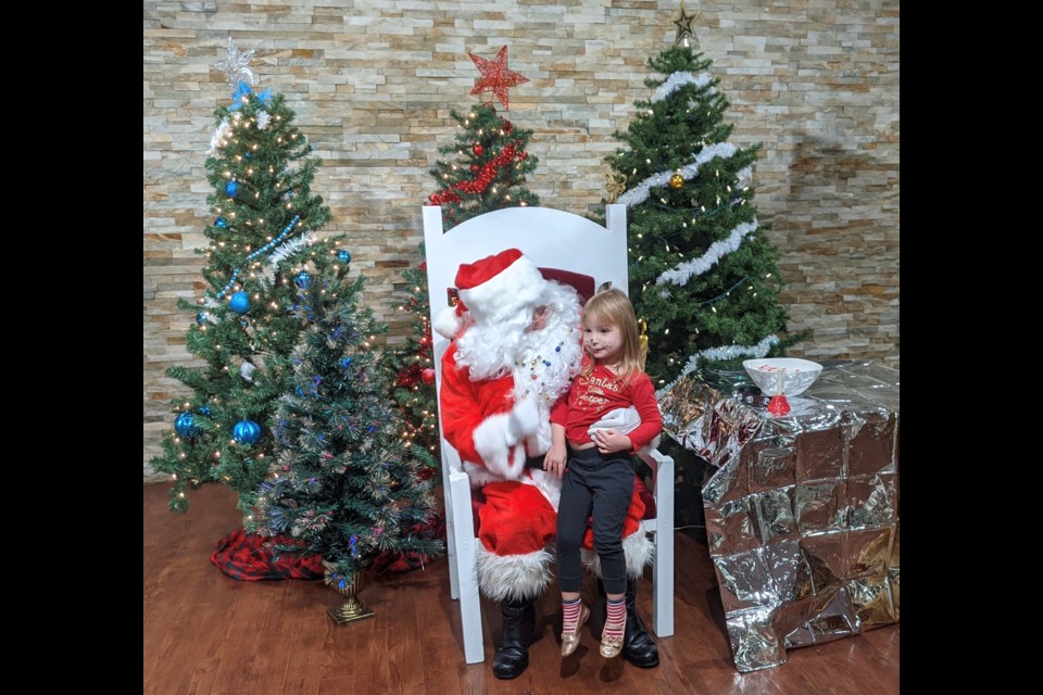 April Lance, 3, tells Santa Claus what she wants for Christmas during an event Saturday morning at the Lion’s Gate Banquet Centre.