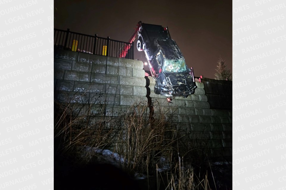 Crews from Classic Towing work to retrieve a pickup truck after it crashed through a fence and landed approximately 20 feet below a parking lot in Barrie's north end.