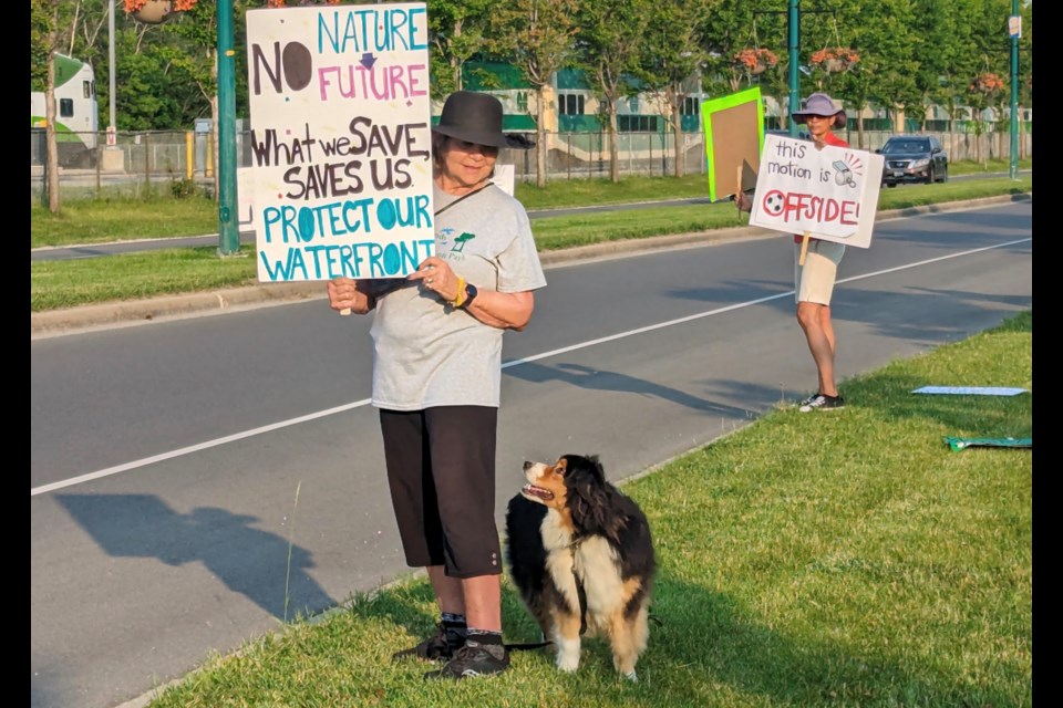 Cherin Harris-Tucker, with her Australian shepherd Tucker, and Michele Newton are shown at Tuesday's sports field protest along Lakeshore Drive.