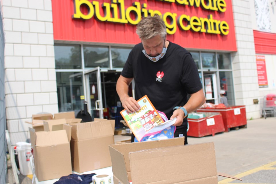 Craig Russell, co-owner of PIE Wood Fired Pizza Joint in Barrie, along with a group of volunteers, fill and packed more than 1,500 backpacks for kids in need on Saturday at the Allandale Home Hardware. 