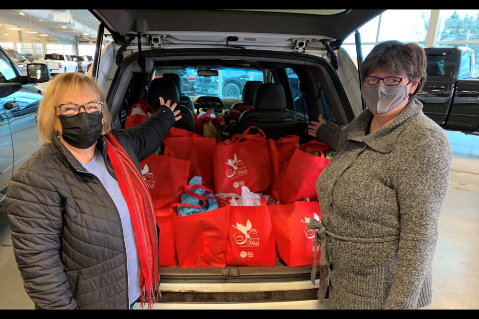 Senior Wish Association chair Pat Imrie and Katrine Laroque, of 400 Chrysler400 Chrysler Dodge Jeep Ram pack up bags of hope to give out to local seniors. 
