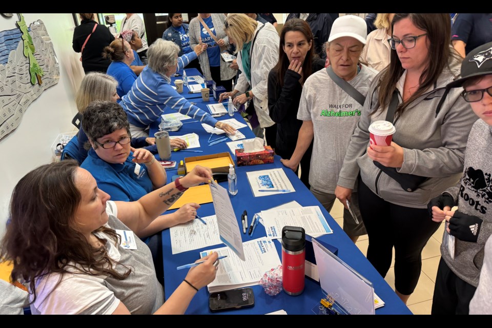 Volunteers register participants as they arrive on Sunday, May 26 for the IG Wealth Management Walk for Alzheimer’s.