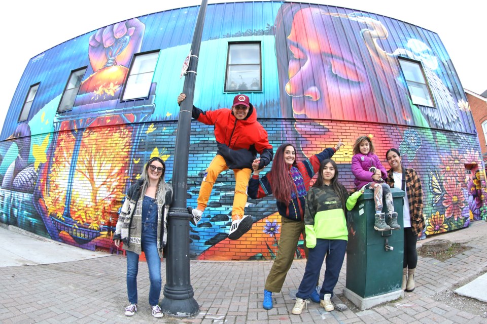 The latest mural painted by Clandestinos, an artistic duo consisting of married couple Bruno Smoky and Shalak Attack, both in red, along with family and friends at the Mary and Dunlop streets location in downtown Barrie.