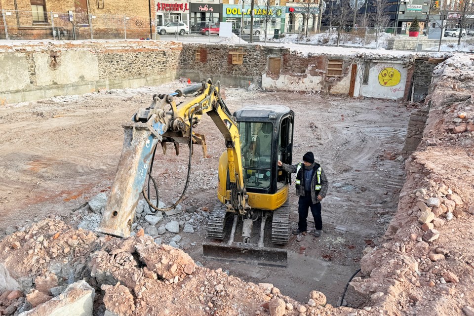 Mike Camplone, an equipment operator with demolition contractor North 7, gets back into his machine on Friday morning. He is shown in the hole that was recently a large, pink, early 1900s abandoned building in downtown Barrie.