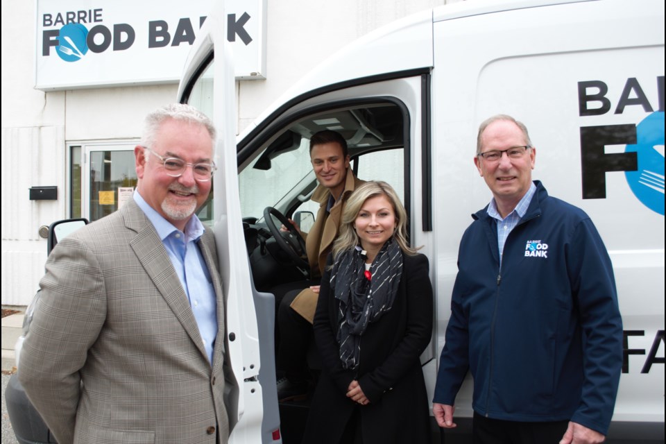 From left, Mike Gibbons, chair of the board for the Barrie Food Bank, Mark and Joanna Faris of Faris Team and Peter Sundborg, executive director with the Barrie Food Bank, show off the new refrigerated food van donated by The Faris Team. Jessica Owen/BarrieToday