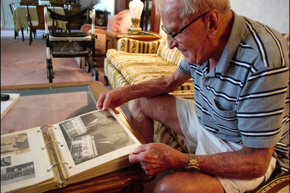 Willard Kinzie, former mayor of Barrie and former owner of Lakeview Dairy, pores over photos of the dairy from its heyday. Jessica Owen/BarrieToday