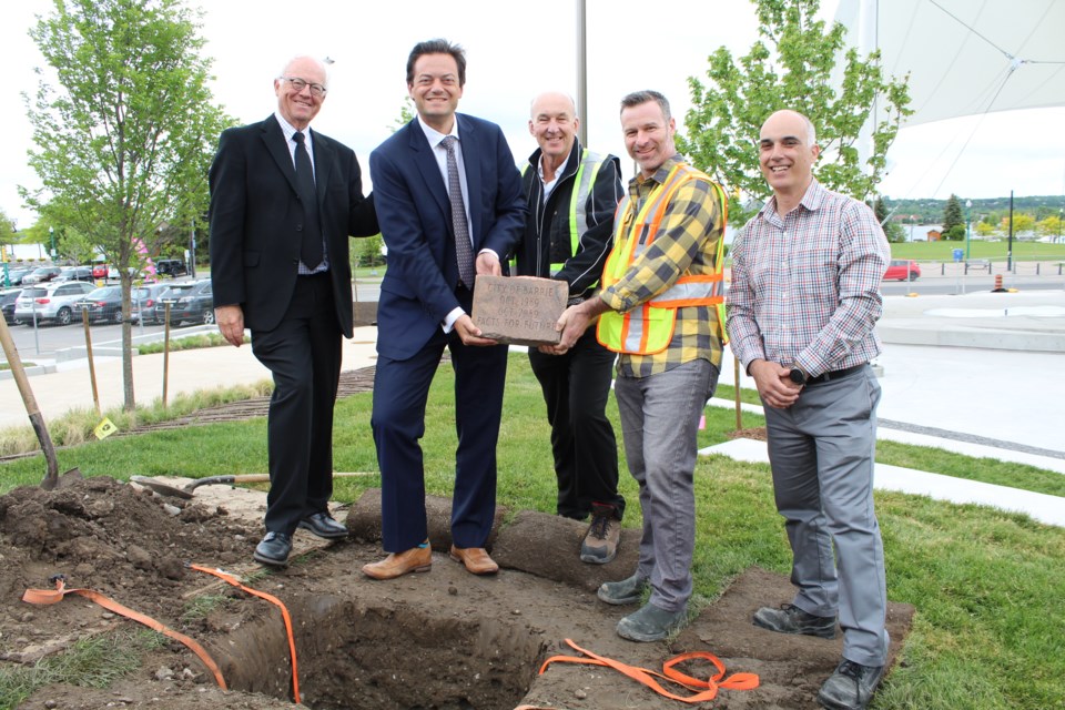 A time capsule that was initially buried in 1989 was placed back in the ground, Monday, at Memorial Square/Meridian Place in downtown Barrie. From left are Bob Lehman, Mayor Jeff Lehman, Downtown BIA chair Wayne Hay, Downtown BIA managing director Craig Stevens and City of Barrie manager of corporate facility services Gus Diamantopoulos. Raymond Bowe/BarrieToday