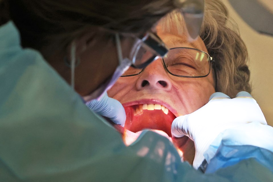 Marie Comeau is assessed prior to receiving her new dentures at the Georgian College dental clinic on Monday.