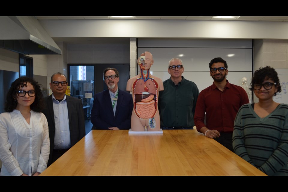 Members of Georgian College’s research team who are leading an intelligent tutoring system project with Meta are inside the research lab to program the Ray-Ban Meta smart glasses they’re wearing with anatomy course curriculum to aid in student learning. From left: Andrea Vargas, Sanjeev Kumar, Rob Theriault, Dr. Sean Madorin, Clinton D’Almeida and Alina Viju.