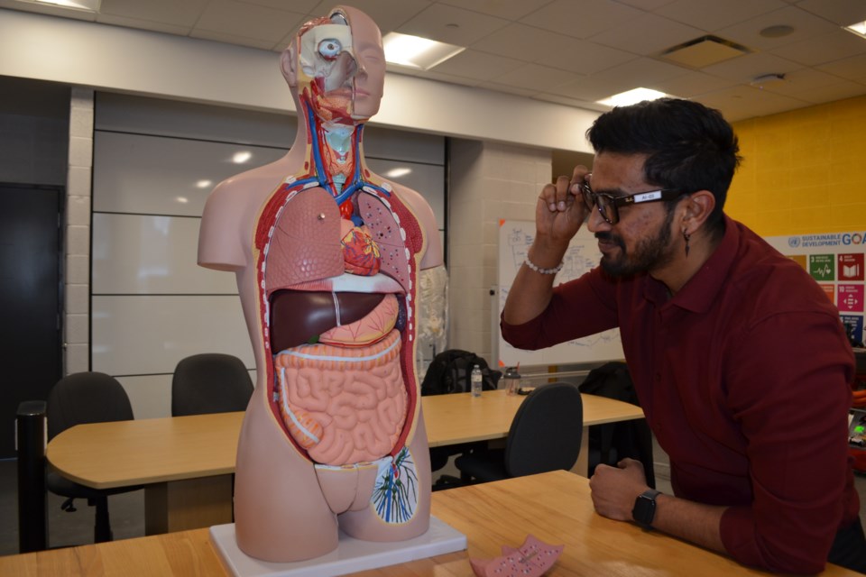 Georgian College student researcher Clinton D’Almeida uses his Ray-Ban Meta smart glasses to study the function of the heart in the anatomical model.