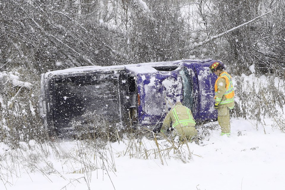 Barrie fire fighters inspect a truck that was involved in a single vehicle accident just north of Duckworth Street on the nortbound lanes of Highway 400 just before 2 PM on Saturday, Feb. 10, 2018. The vehicle left the highway and ended up along the fence line after rolling.  Kevin Lamb for BarrieToday.  