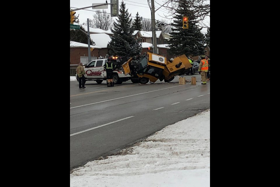 A tow truck picks up a snow plow that tipped while crossing an intersection in Barrie, Thursday afternoon. Photo submitted by Steve Bradley