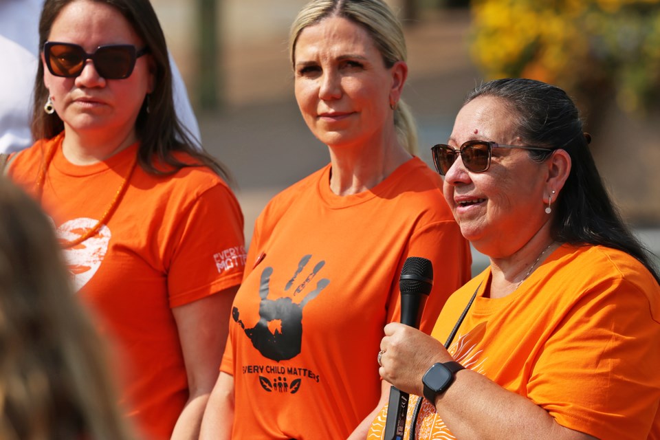 Paula West Oreskovich, centre, listens to a fellow speaker at Barrie City Hall on Friday during a flag-raising ceremony to mark the National Day for Truth and Reconciliation on Sept. 30, which is a national holiday.