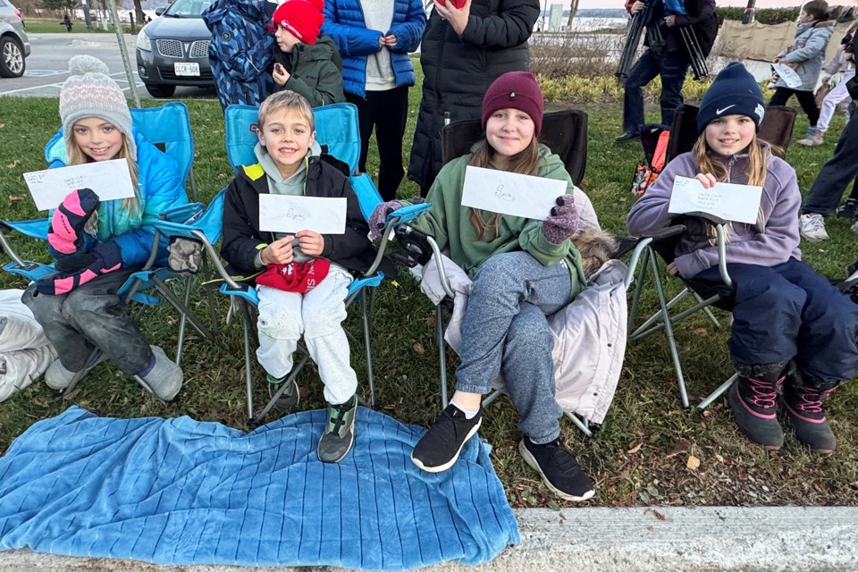 Morgan, Roman, Dahlia and Audrey wait patiently with their letters to Santa prior to the start of the Barrie Santa Claus Parade on Saturday along Lakeshore Drive.