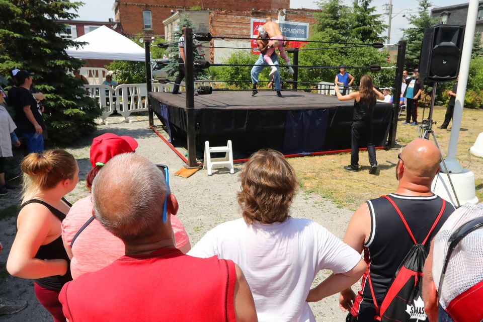 Patient 705 manhandles his opponent as visitors to the downtown take in the match during Barrie Wrestling's Canada Day Clash 2 wrestling tournament at Promenade Days held downton on Dunlop Street in Barrie on Saturday, June 30, 2018. The action continues at the 5-Points all weekend. Kevin Lamb for BarrieToday.