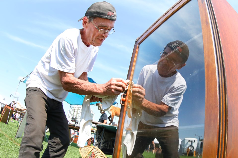 Gordon Buist of Montreal, and a vendor here for more than 28 years, shines up an antique cabinet at Kempenfest, which sprawls along the waterfront in Barrie on Saturday, August 4, 2018. Kevin Lamb for BarrieToday.