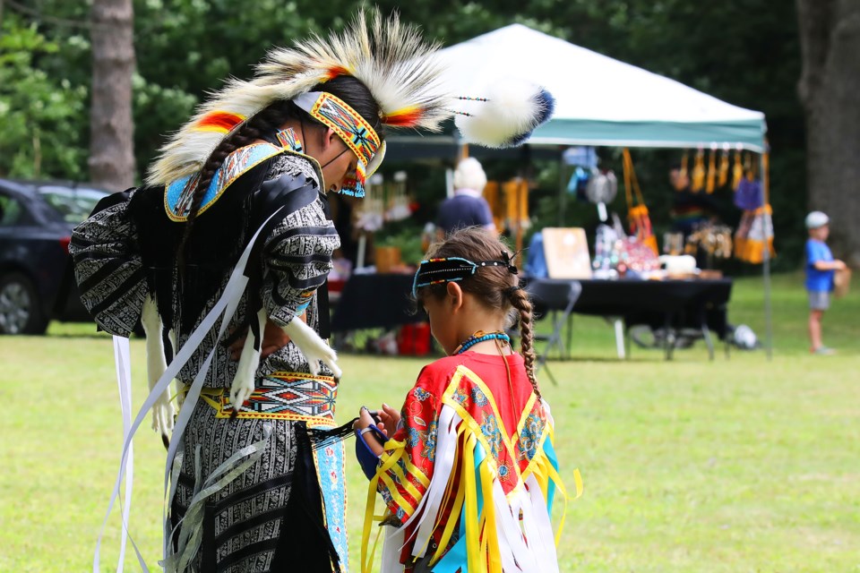 Zydin Good, right, helps Tyrone Jones get ready for the first annual Beausoleil First Nation Niizh Manidook Pow Wow that was held at Springwater Provincial Park near Barrie on Saturday, August 4, 2018. The pow wow was organized by the youth of the community in support of the LGBTQ Community.. Kevin Lamb for BarrieToday.