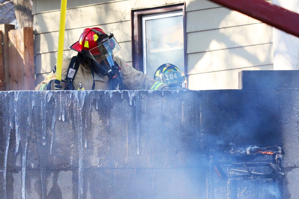 Barrie firefighters stamp out the remaining hotspots of a garage fire at 90 Maple Avenue in Barrie on Saturday, May 5, 2018. Kevin Lamb for BarrieToday.