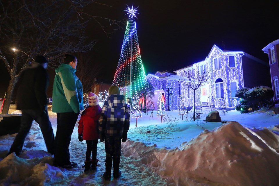 Visitors to Violet Street in Barrie take in the sound and light show at Dino Sangiuliano's home on Saturday, December 23rd, 2017. It takes Dino two months to set up the decorations and he has been doing it every year for over a decade. There is also a donation box with proceeds going to Make-A-Wish Canada. Kevin Lamb for BarrieToday 