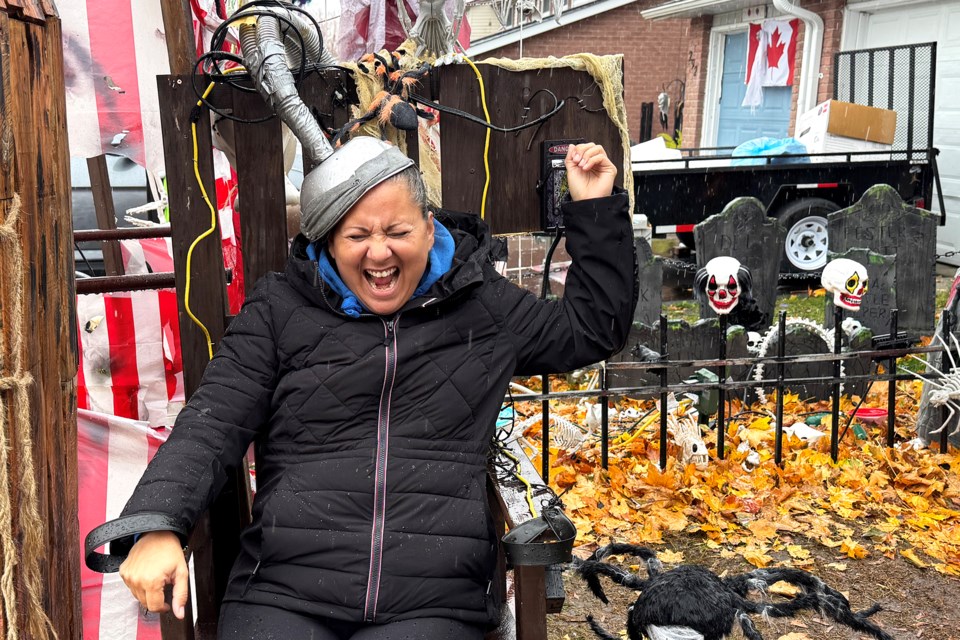 Rosemarie McKenzie, creator of Barrie's Halloween Enthusiasts!, and a resident who hosts her own family's haunt at 288 Browning Trail in Barrie, tries out an electric chair.