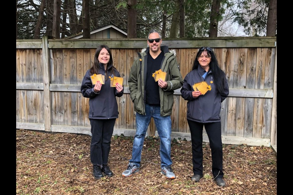 From left, Paige Russell, Greg Dumoulin, Tracey Fox hold up the Moose Hide pins available through the Barrie Native Friendship Centre. 