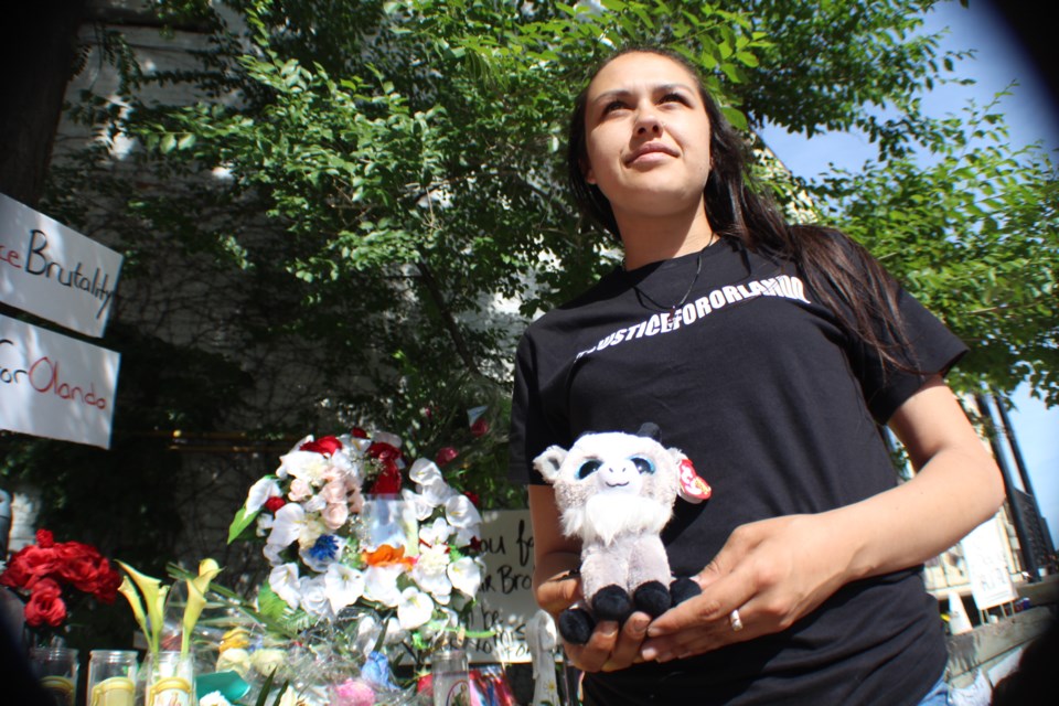 Severena Storkson attends a vigil for friend Olando Brown in downtown Barrie on Tuesday. She brought a small stuffed goat, because she said Brown always talked about his love for Jamaican food, including curried goat.  Raymond Bowe/BarrieToday