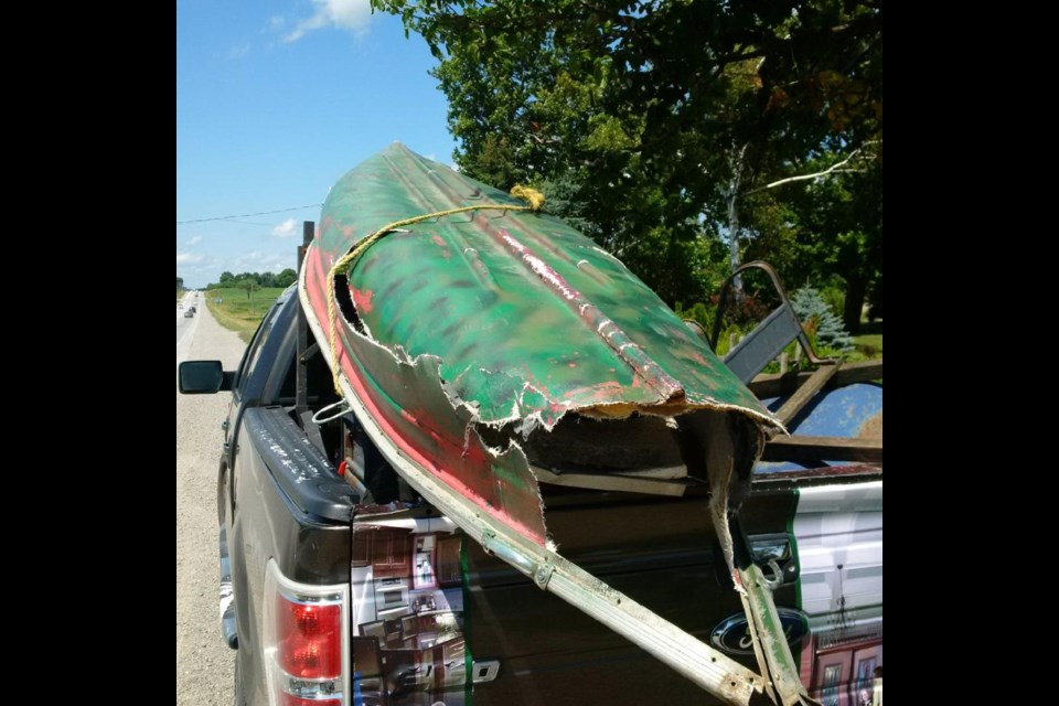 Canoe suffered heavy damage after it fell off the back of a truck and struck a car.   Photo South Simcoe Police Twitter