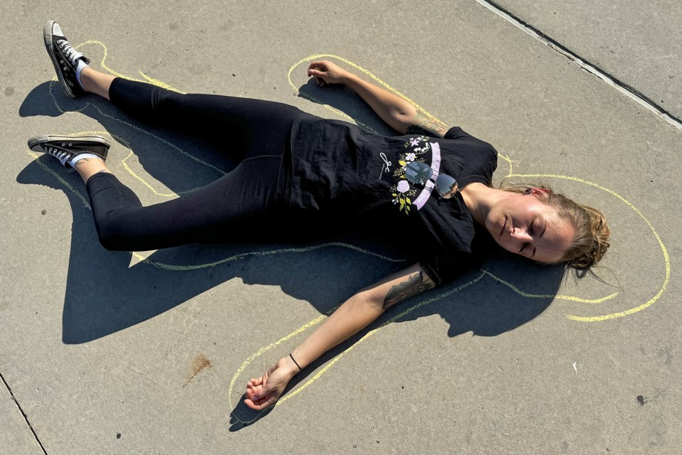 A protester takes part in a die-in protest in support of supervised consumption sites in the province, which are being shut down by the government, at Memorial Square in Barrie on Oct 21, 2024.