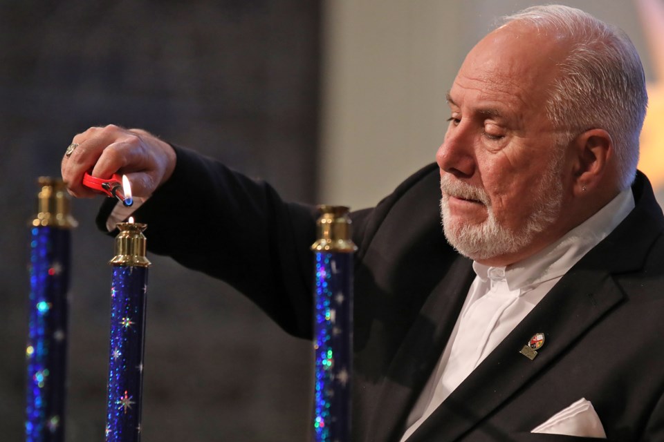 Rob Murdock lights candles during a Christmas Eve service at Collier Street United Church in downtown Barrie. 