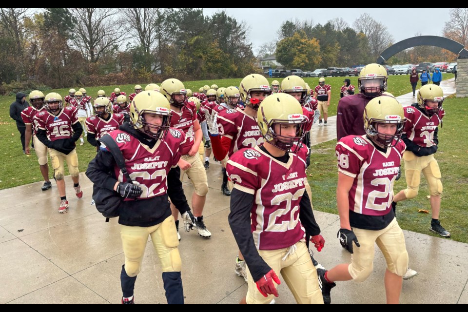 Members of the St. Joseph's Jaguars senior football team head onto J.C. Massie Field in Barrie on Friday. 