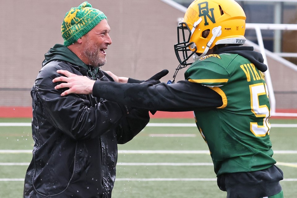 Barrie North Vikings coach Burke Erwin celebrates with one of his players after he had water dumped on him post-game. The Vikings won the Georgian Bay title after defeating the St. Joseph's Jaguars, 13-0, on Nov. 14 at Maple Ridge Secondary School.