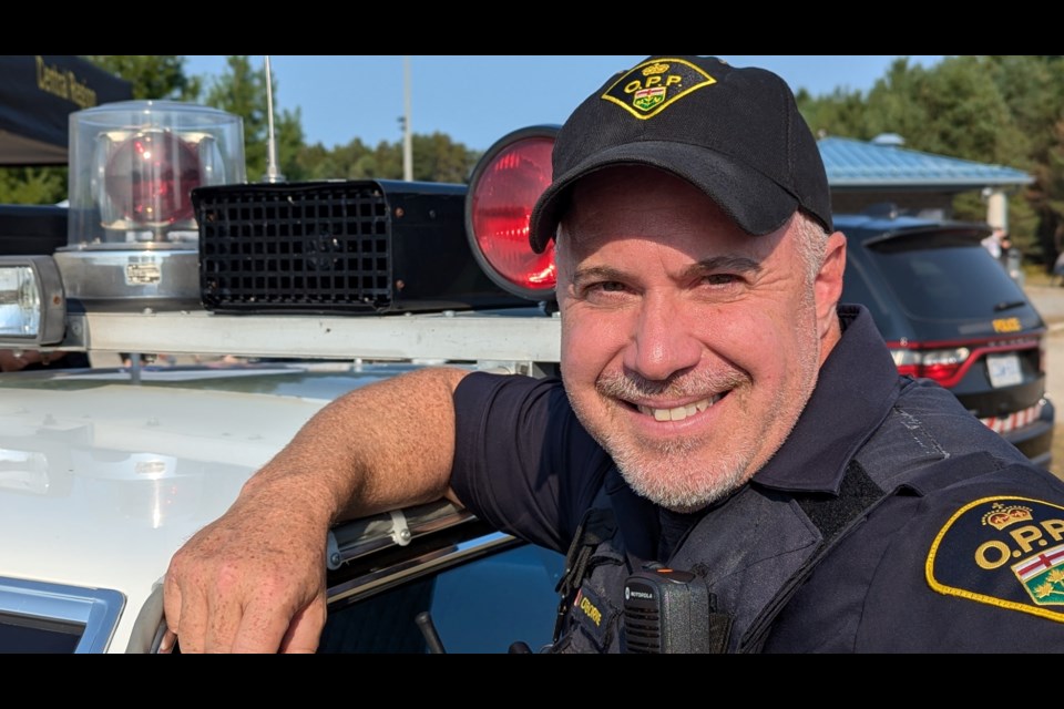 Ontario Provincial Police Const. Mike Osborne shows off a classic OPP cruiser at Springwater Township's 30th birthday party on Saturday at the Tree Nursery Sport Park in Midhurst.