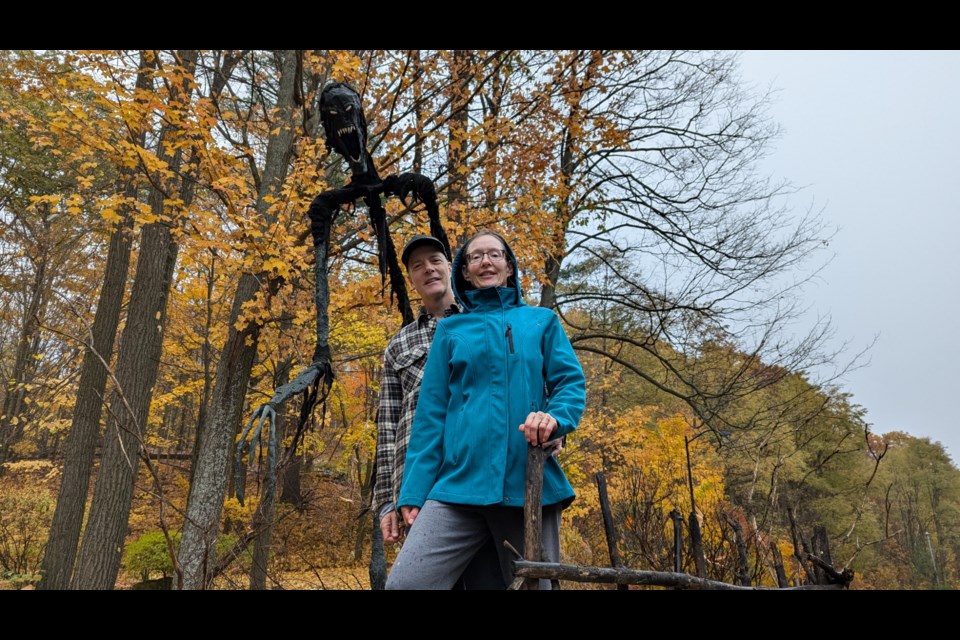 Doug and Joanne Washburn stand in front of DeMummer, the large figurative work that sits at the end of their driveway on Bridle Trail in Midhurst.