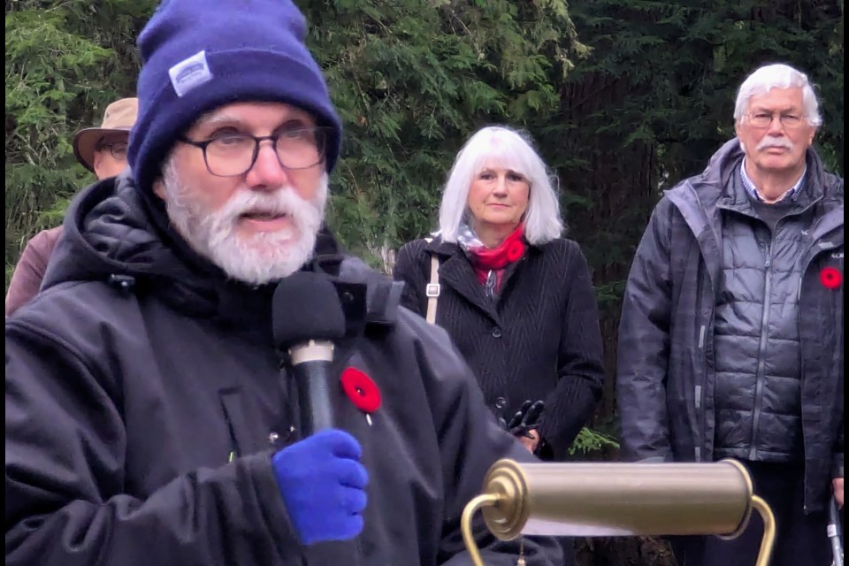 Murray Deller, left, cousin of author John McCrae, reads McCrae's most famous poem, In Flanders Fields, during the Remembrance Day ceremony at Springwater Provincial Park on Monday.