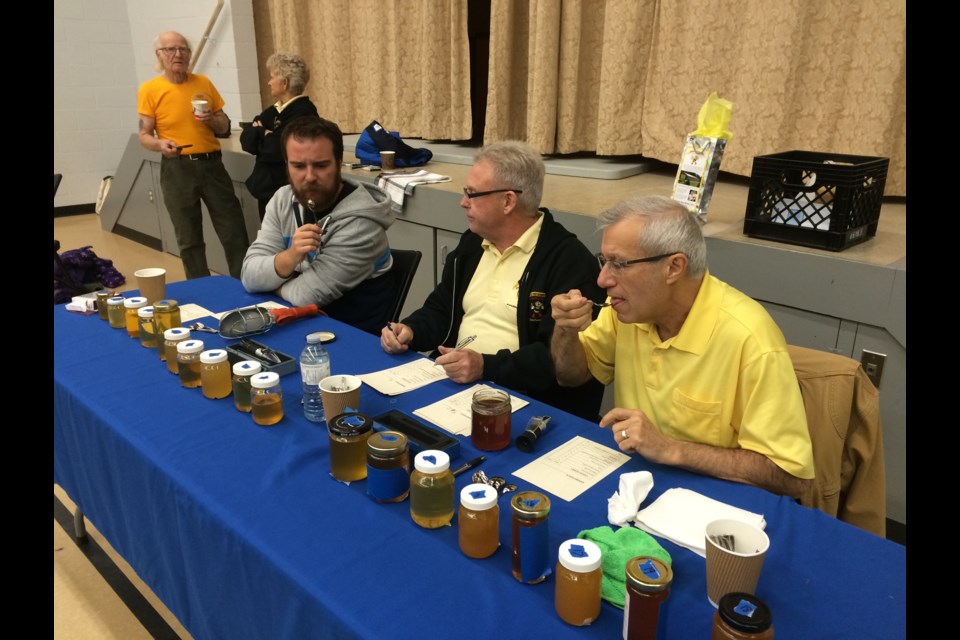 Mike Morrow of Powassan Home Hardware, (L)  Peter Dickey, owner of Dickey Bee Honey in Cookstown (M) and Nipissing MPP and Finance Minister Vic Fedeli judge this years crop of locally produced honey 