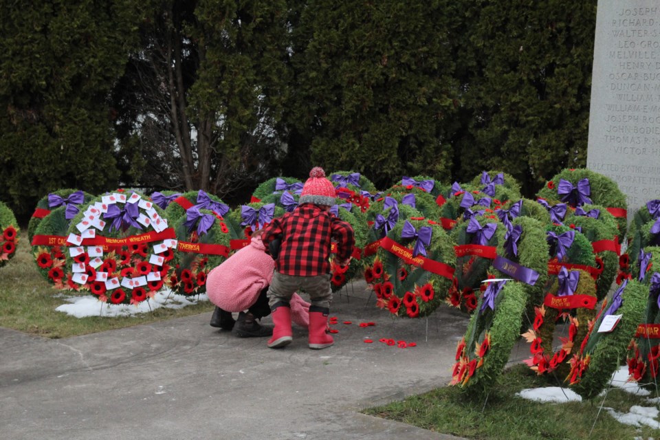 Two little ones lay their poppies down at the cenotaph after the wreath laying ceremony concluded