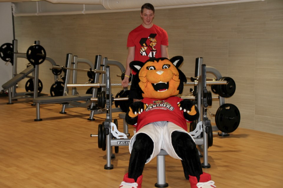 The Canadore Panther does bench press to open the new 4,000 square foot facility.  Photo by Chris Dawson. 