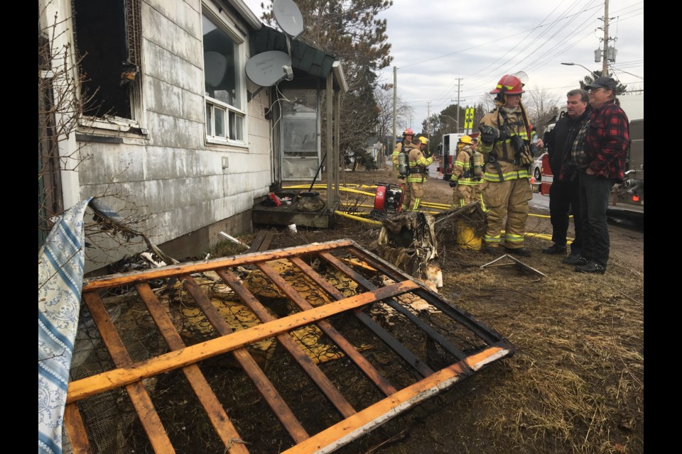 Tenant Tracy Roy (far right) talks to firefighters outside his home.  Photo by Chris Dawson/BayToday.ca. 